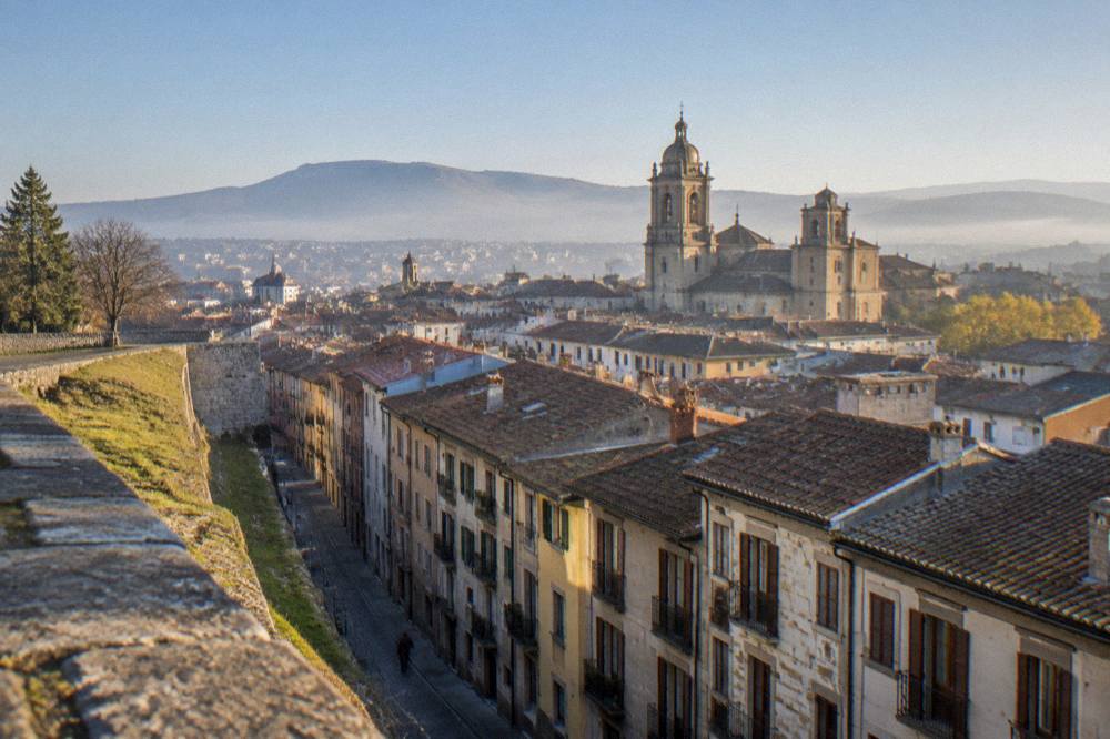 Wide view over Pamplona rooftops and cathedral from the city walls at golden hour