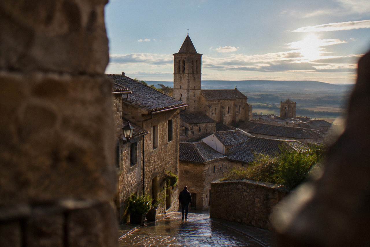 Stone houses and a church tower rising above the rooftops of a medieval hill town in Aragon