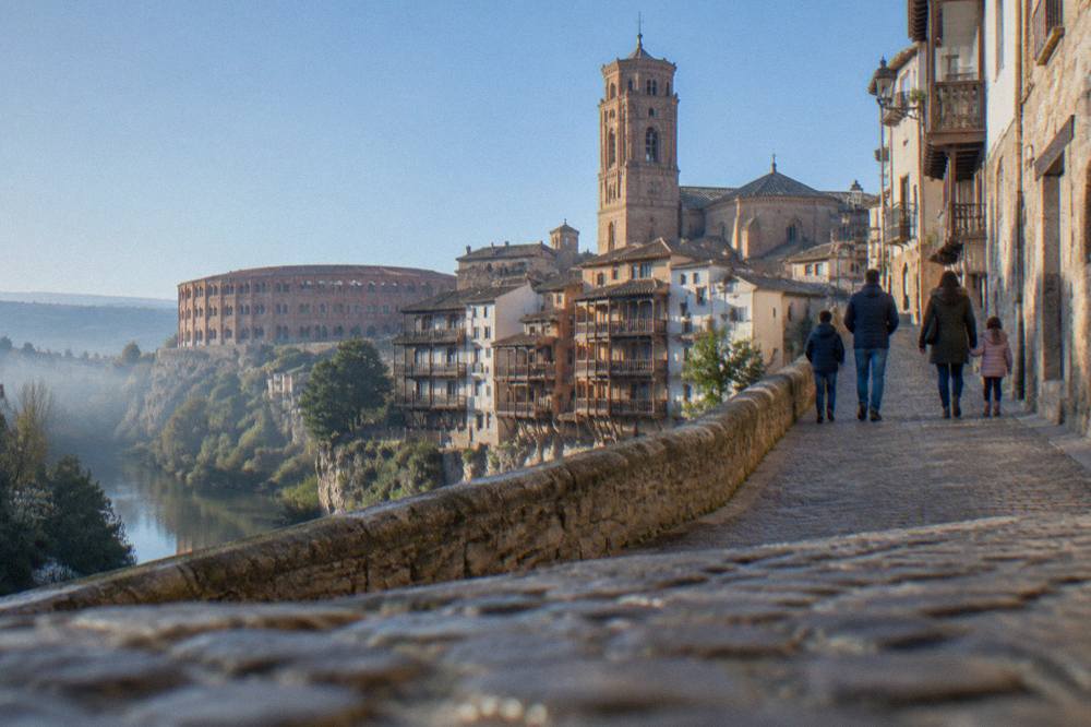 A family walking together up a cobbled street in a small Spanish hill town