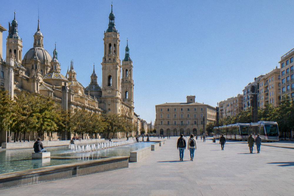 A tram passing modern apartment blocks on a wide avenue in Zaragoza