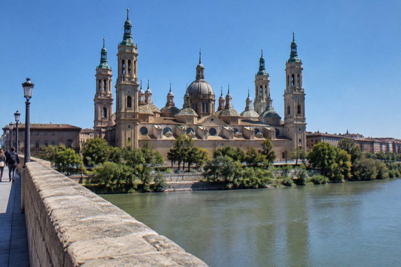 The Basilica del Pilar and its towers seen across the Ebro river from the stone bridge on a clear day