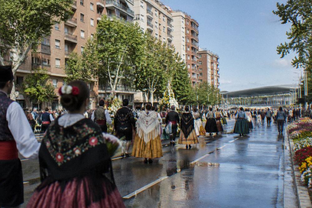 Crowds in traditional Aragonese dress filling a wide city avenue with flowers