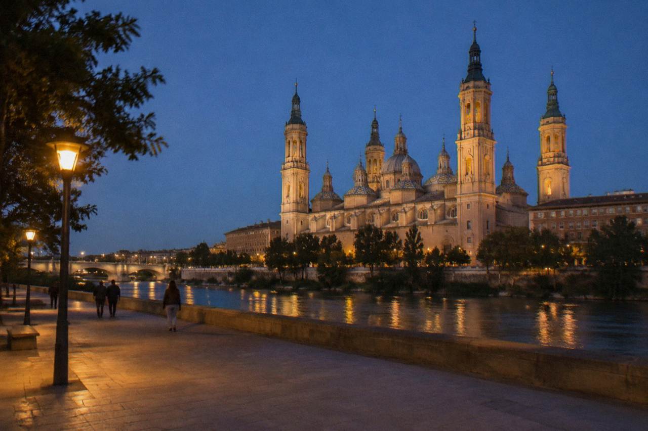 The towers of the Basílica del Pilar rising above the Ebro river at dusk in Zaragoza