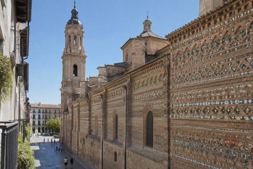 The ornate Mudéjar wall of La Seo cathedral seen from a narrow street in Zaragoza