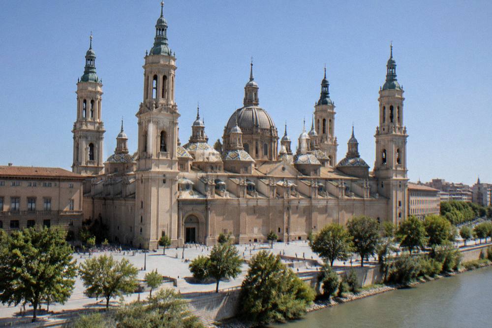 Flowers and candles arranged before the altar of the Basílica del Pilar in Zaragoza