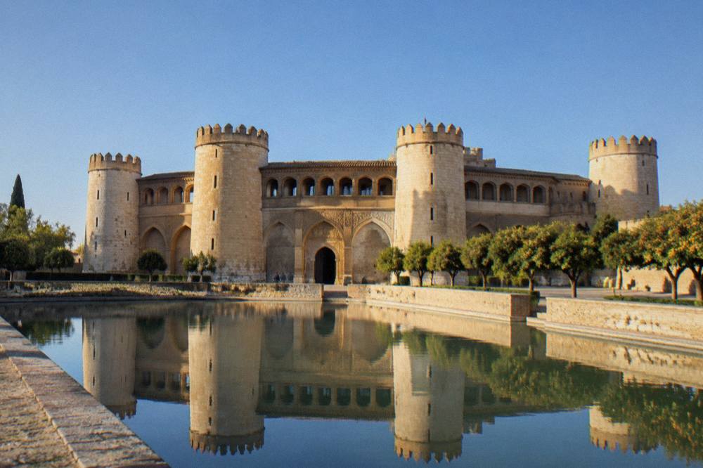 The Aljafería palace in Zaragoza seen across its reflecting pool