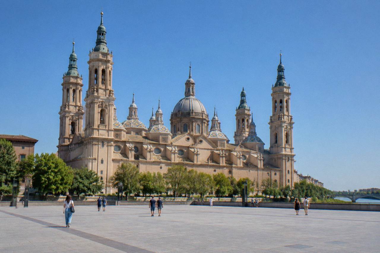 Wide stone square in front of the Basílica del Pilar on a clear day with open paving
