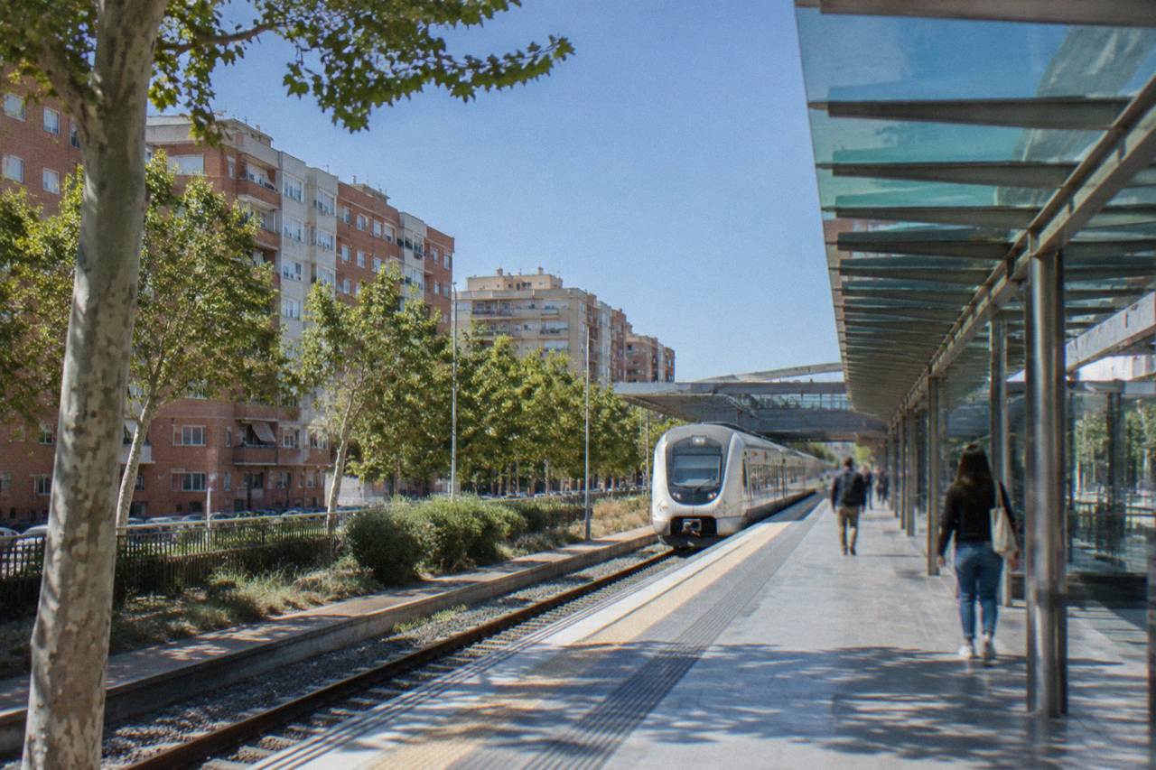The glass and steel platforms of a modern Spanish railway station under daylight