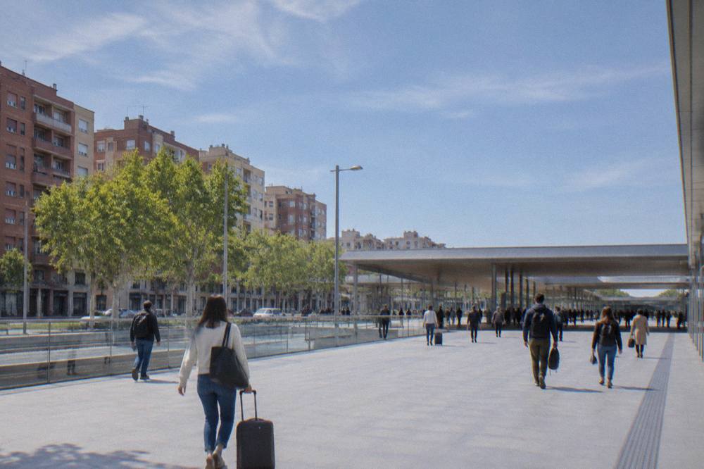Travellers walking across a bright station concourse with departure boards overhead