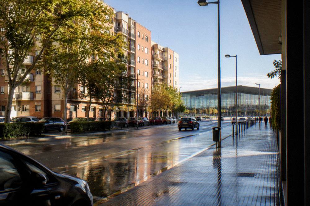 The modern glass facade of Zaragoza-Delicias railway station under a clear sky