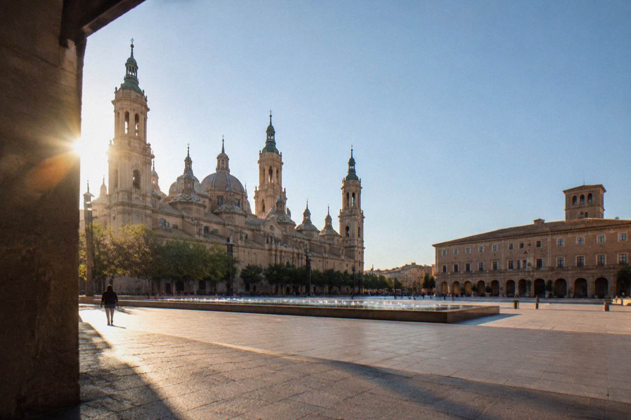 A quiet old-town street in Zaragoza with stone buildings under a clear sky