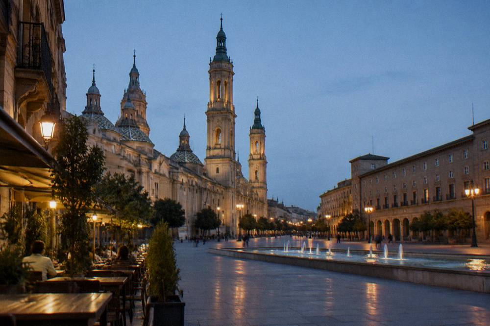 A narrow tapas street in Zaragoza's old town lit up in the evening