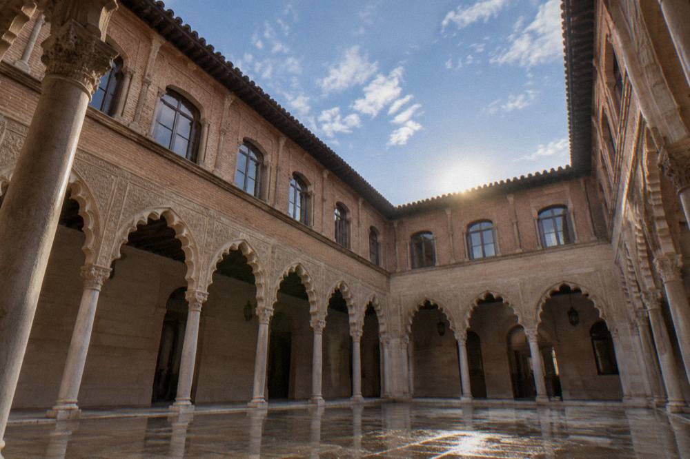A colonnaded courtyard with carved stone arches in an Islamic-style palace