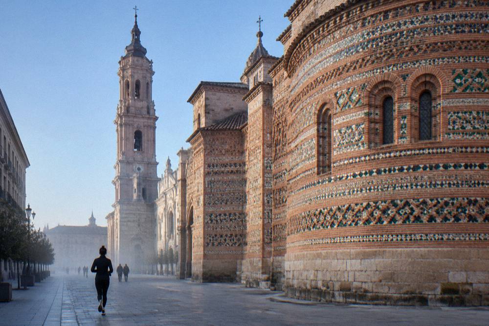 The banded brick and glazed tile apse wall of La Seo's Parroquieta in afternoon light