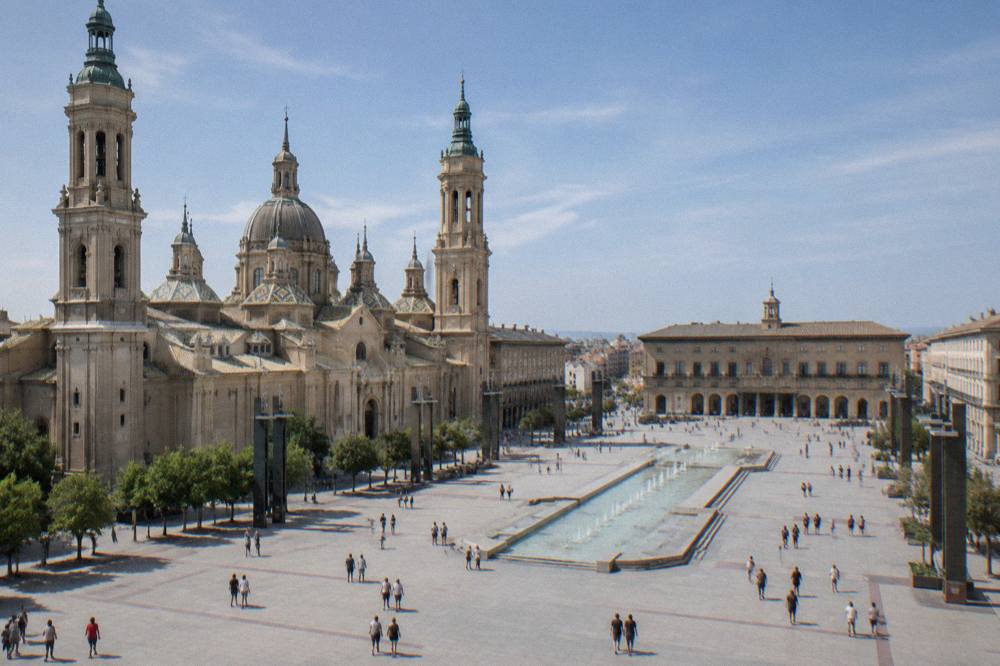 Plaza del Pilar in Zaragoza with the basilica and cathedral seen in daylight with people crossing the square