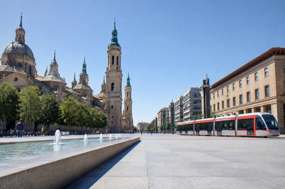 A Zaragoza tram passing along a city street with modern buildings behind it