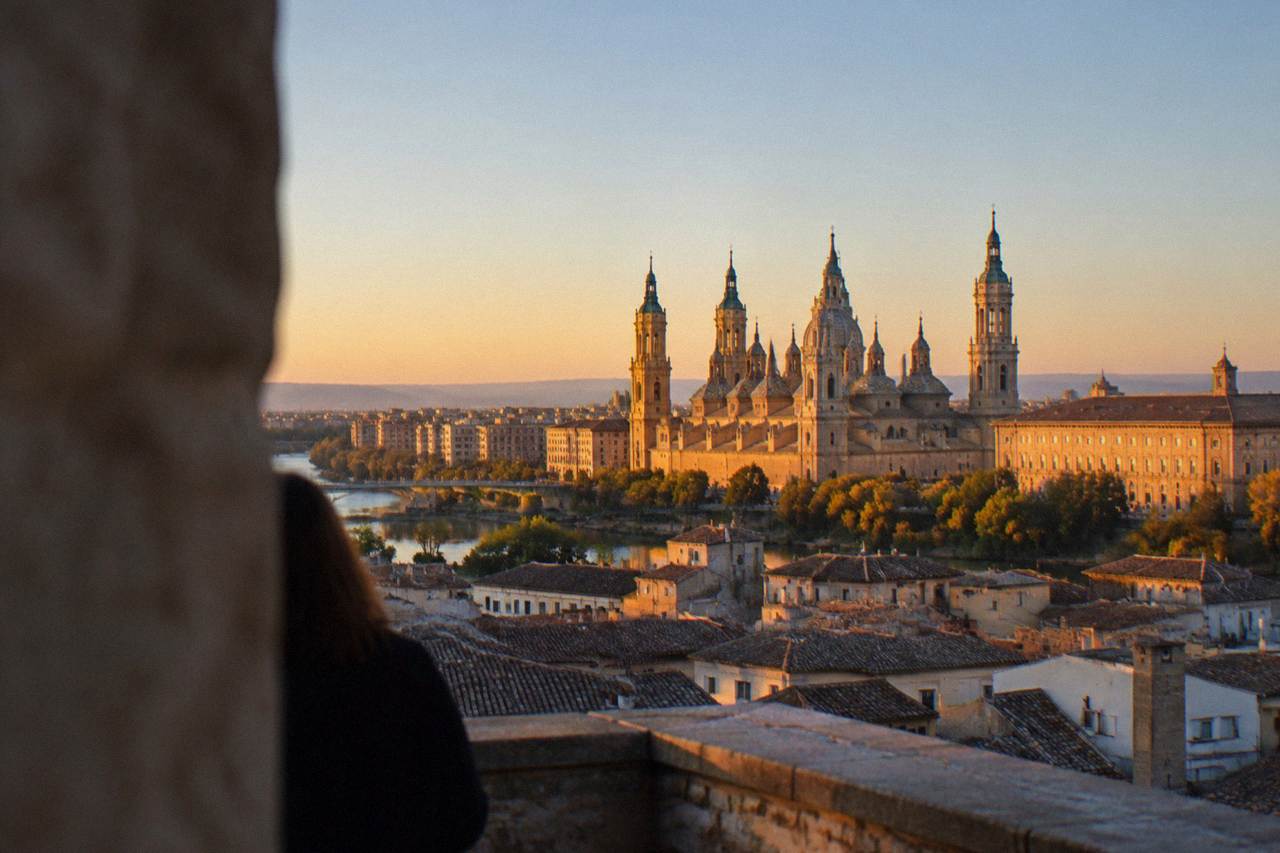 A view over Zaragoza rooftops towards the Basilica del Pilar towers in warm evening light