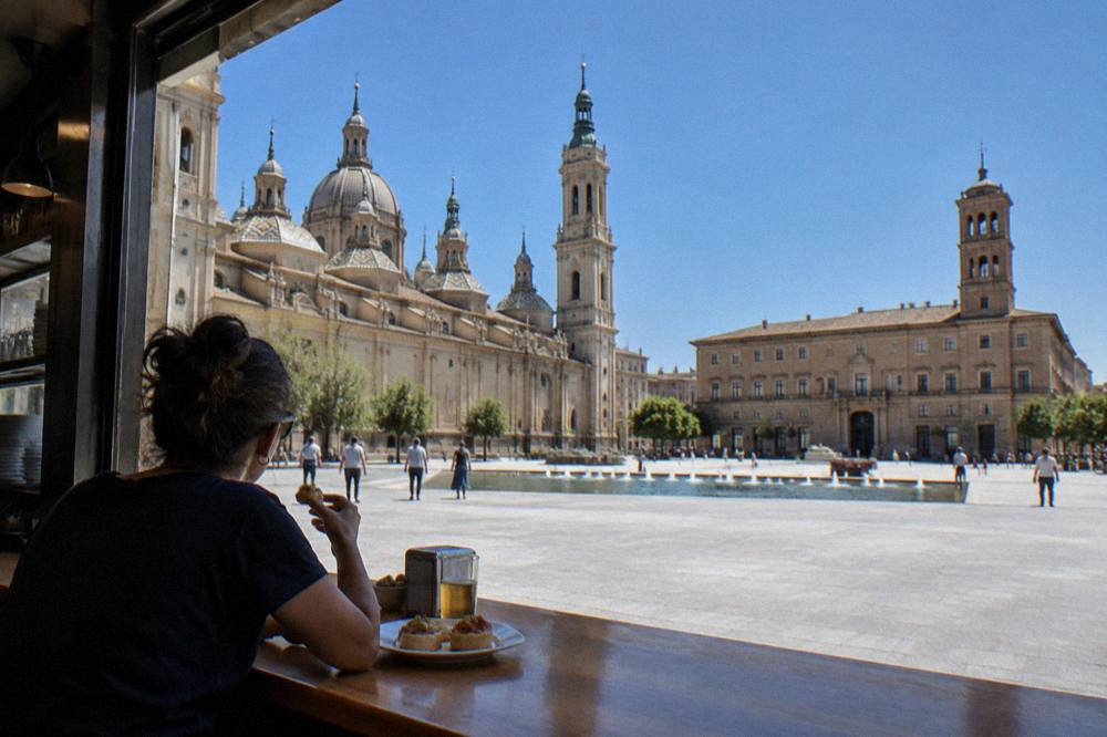 A person eating tapas alone at a busy bar counter in Zaragoza's old town