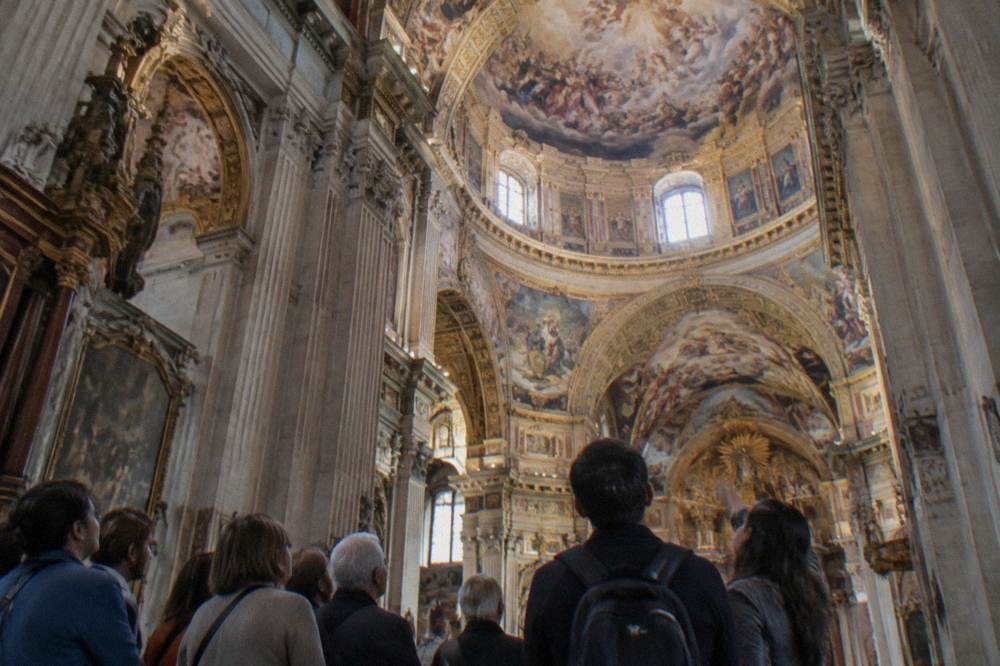 Visitors looking at the painted ceiling inside the Basilica del Pilar on a guided visit