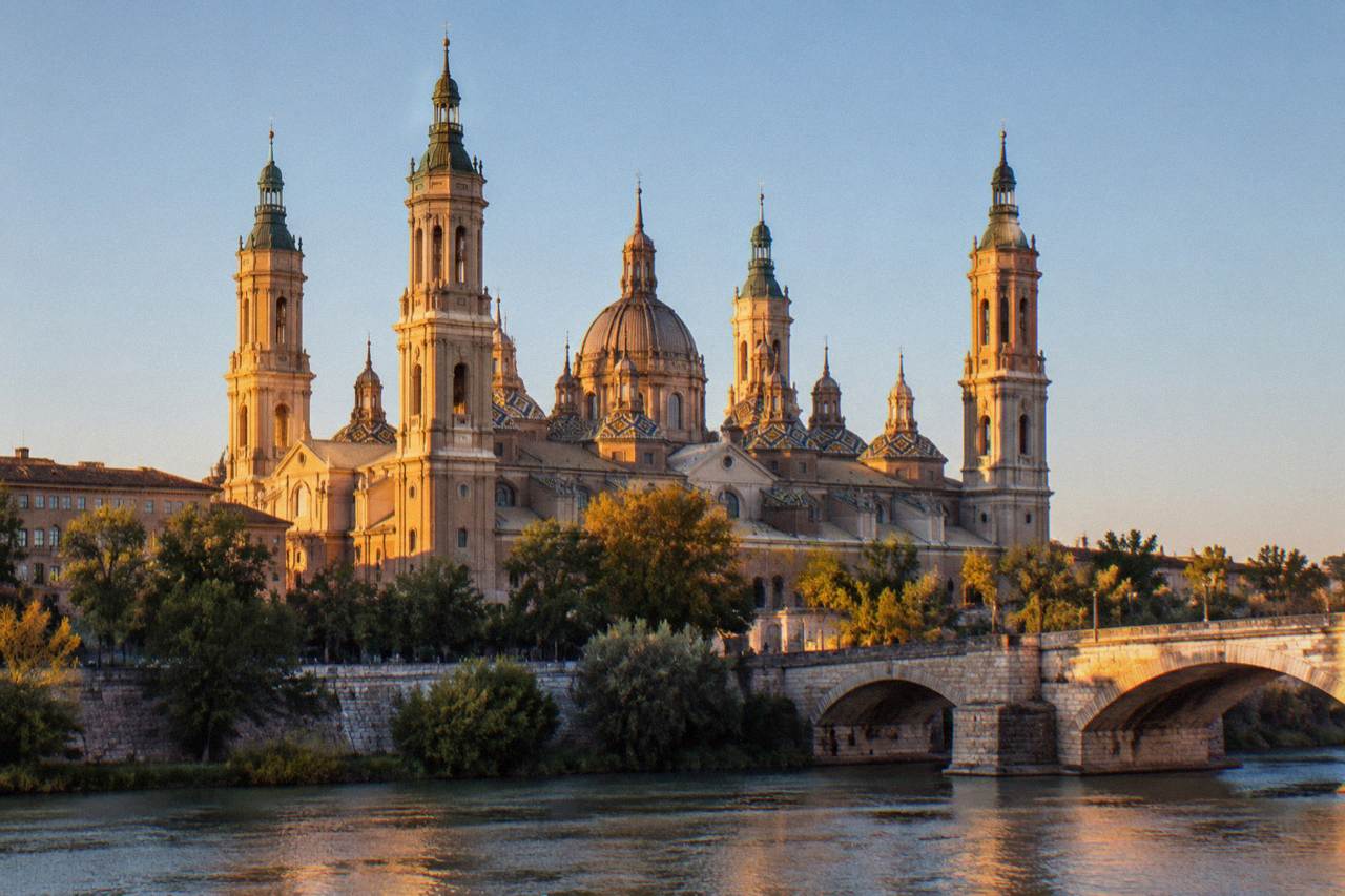 The Basilica of Our Lady of the Pillar rising above the Ebro river in Zaragoza at golden hour