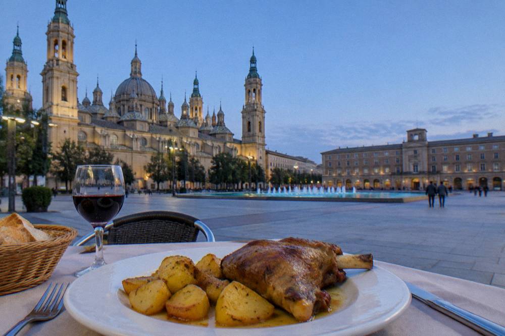 A plate of ternasco roast lamb with potatoes on a restaurant table in Zaragoza