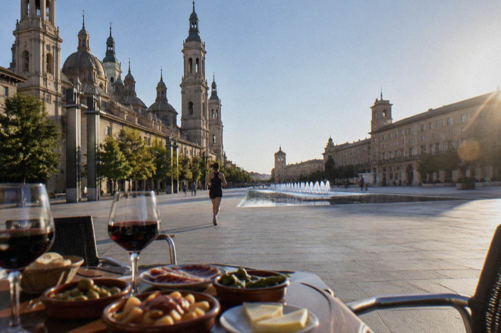 A table set with tapas dishes and glasses of red wine in an old town bar
