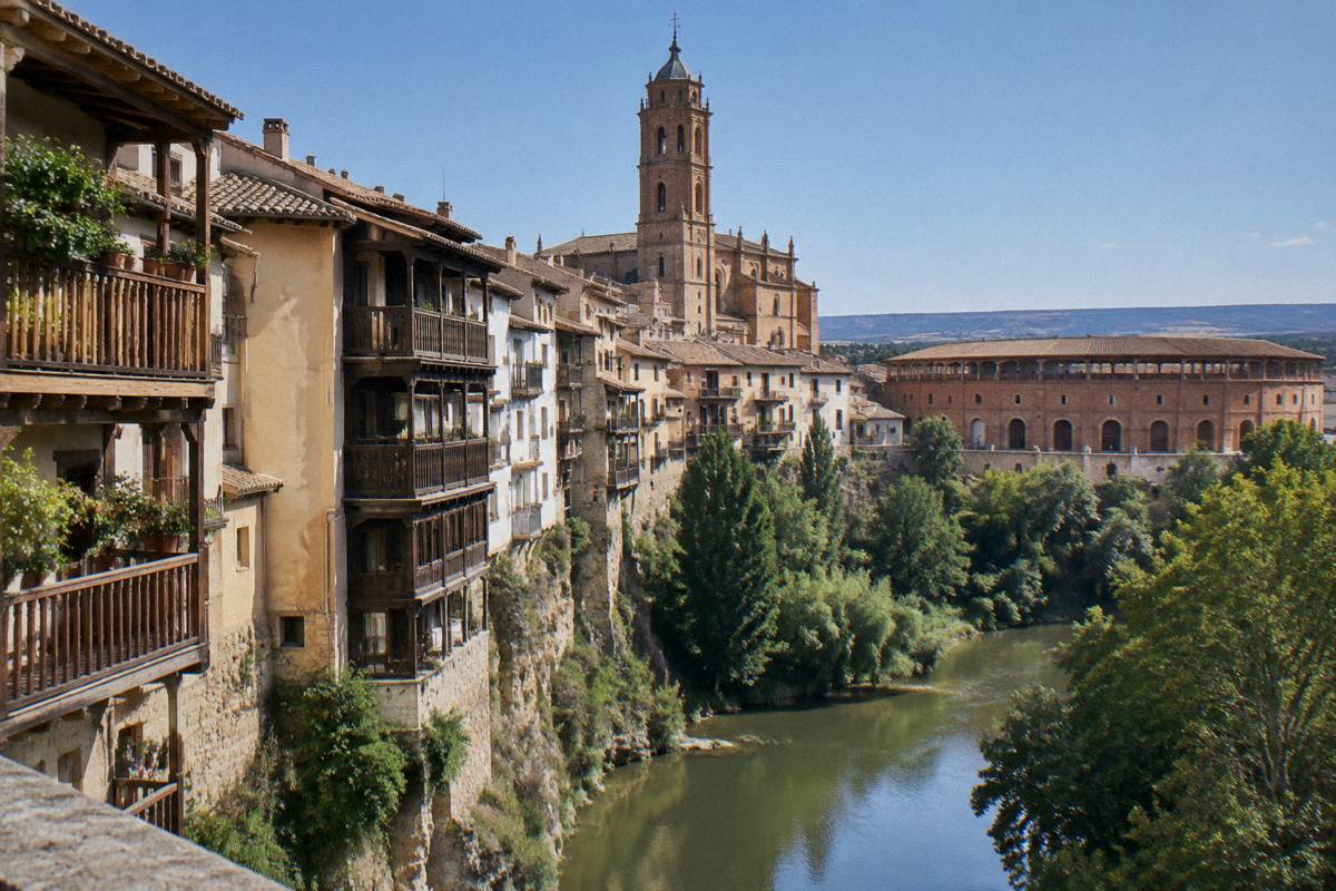 Tall hanging houses on a river bank under a cathedral tower