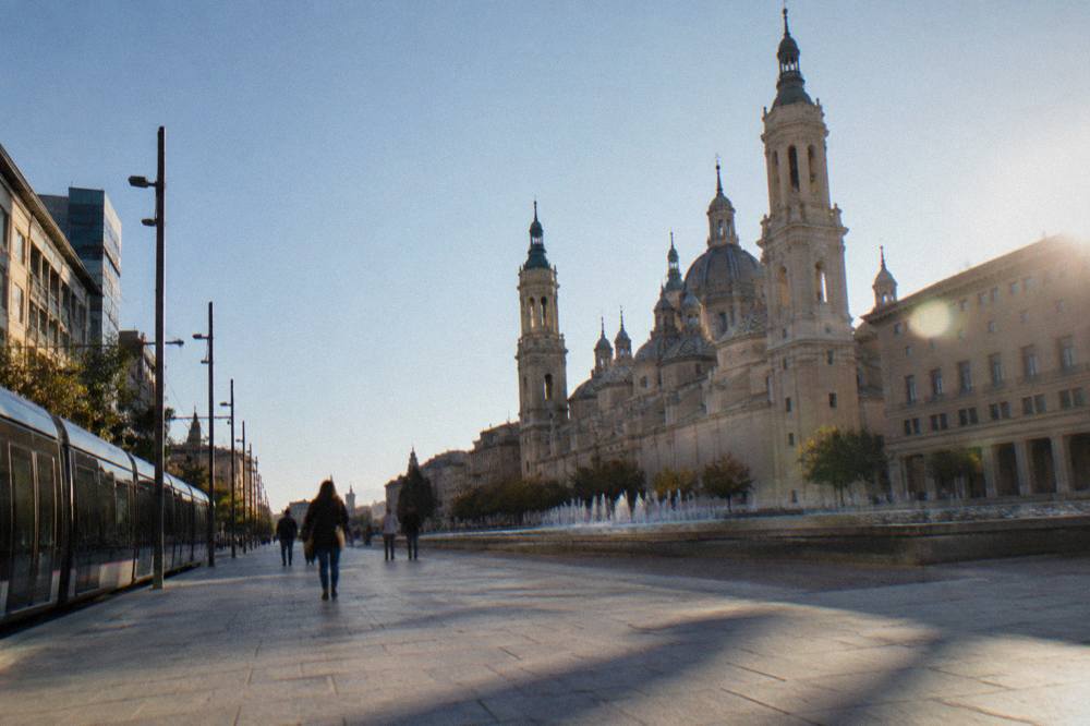 A tram passing modern buildings on a wide avenue in central Zaragoza