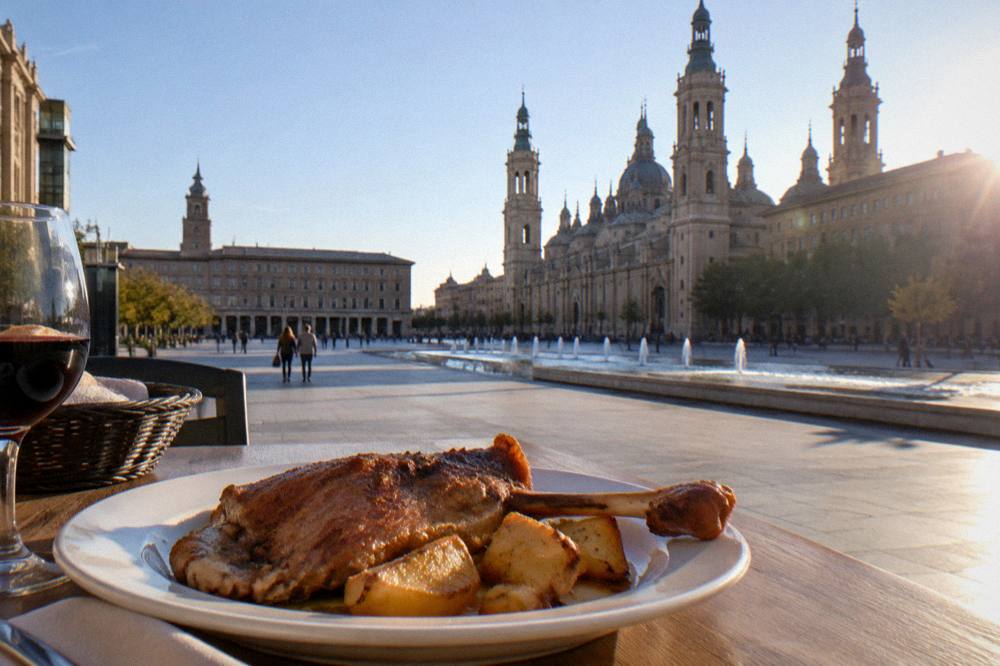 A plate of roasted ternasco lamb with potatoes on a restaurant table in Zaragoza
