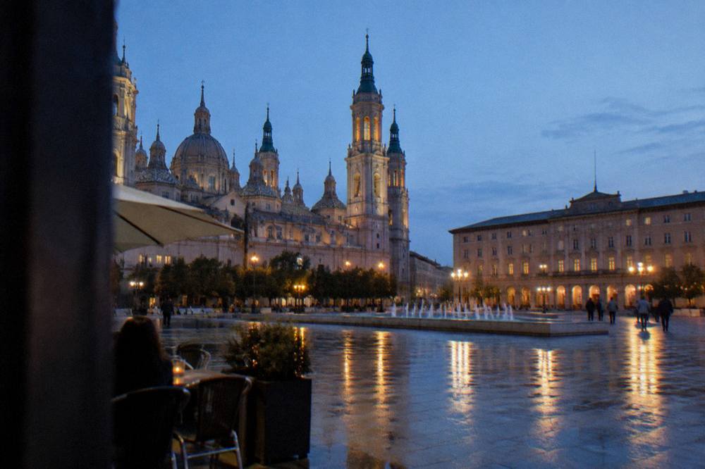 Evening light on a tapas street in Zaragoza with lit windows and wet pavement