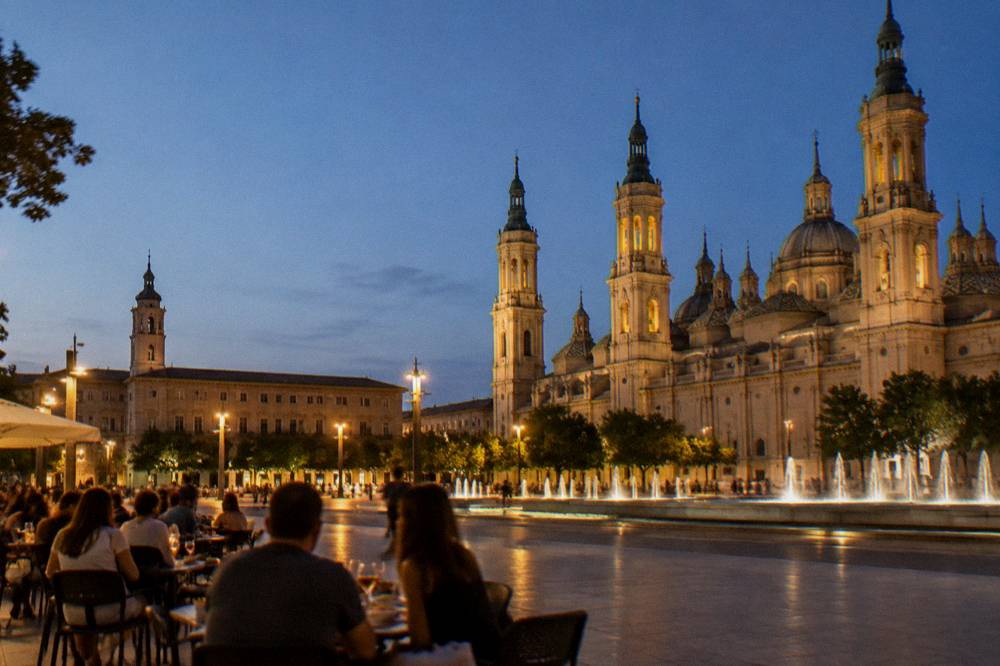 People eating tapas at outdoor tables on a warm evening street in Zaragoza